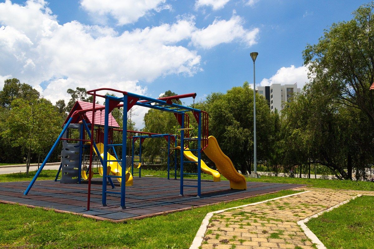 Área verde con juegos infantiles en el desarrollo